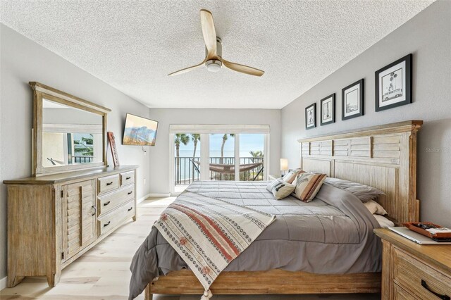 bedroom featuring a textured ceiling, ceiling fan, access to exterior, and light hardwood / wood-style floors