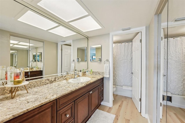 bathroom featuring toilet, vanity, and hardwood / wood-style floors