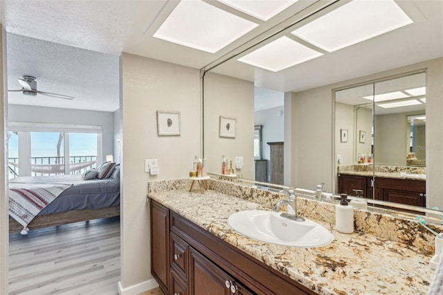 bathroom featuring a textured ceiling, ceiling fan, hardwood / wood-style floors, and vanity