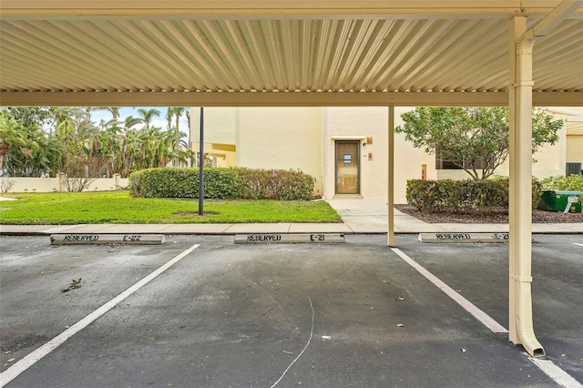 view of parking with a carport and a yard