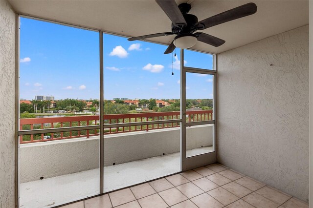 unfurnished sunroom with ceiling fan