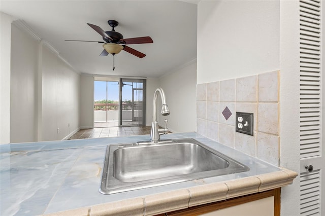 kitchen with ceiling fan, ornamental molding, and sink