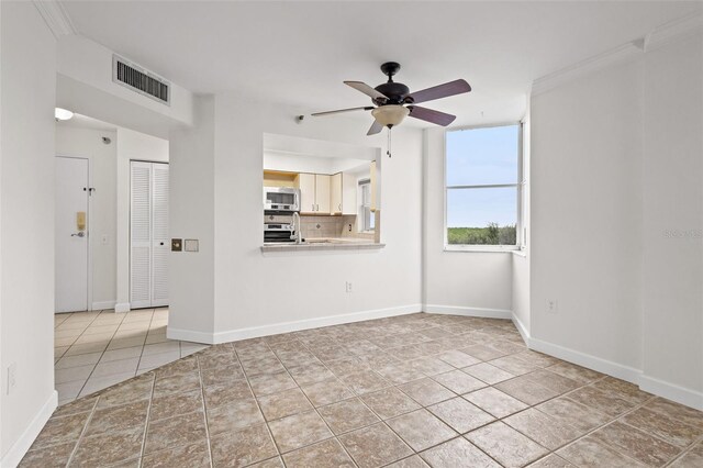 unfurnished living room with light tile patterned flooring, ceiling fan, and crown molding