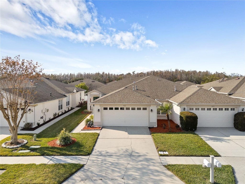 ranch-style home featuring a garage and a front lawn