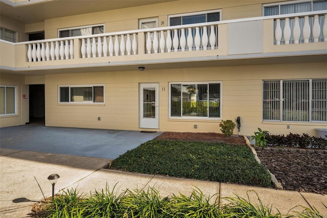 view of exterior entry with a balcony