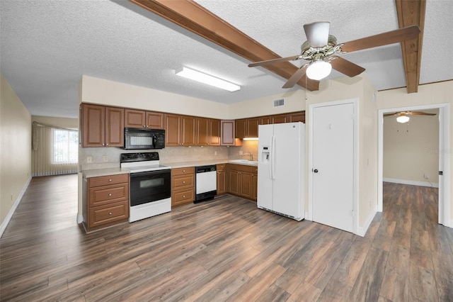 kitchen with white appliances, dark hardwood / wood-style flooring, sink, and beam ceiling