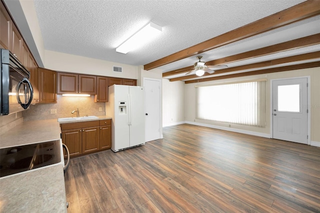 kitchen with dark hardwood / wood-style floors, beamed ceiling, tasteful backsplash, sink, and white fridge with ice dispenser