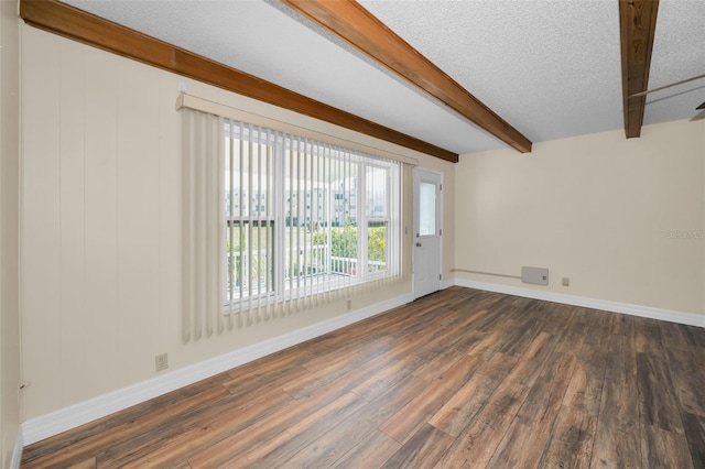 spare room with beam ceiling, dark wood-type flooring, and a textured ceiling