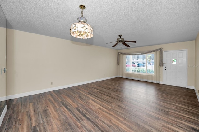 unfurnished living room with ceiling fan, dark hardwood / wood-style floors, and a textured ceiling