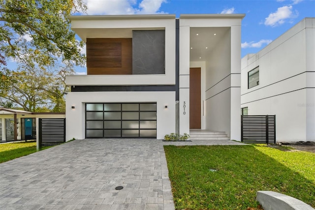 modern home featuring a front yard and a garage