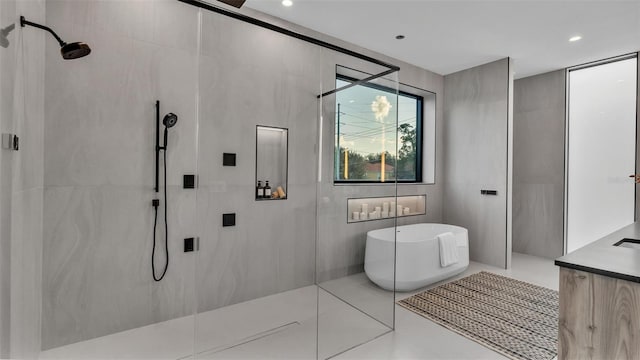 bathroom with tile walls, vanity, tile patterned floors, and independent shower and bath