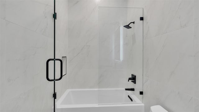 bathroom with toilet and combined bath / shower with glass door