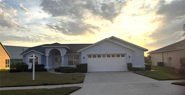 ranch-style house featuring a lawn and a garage