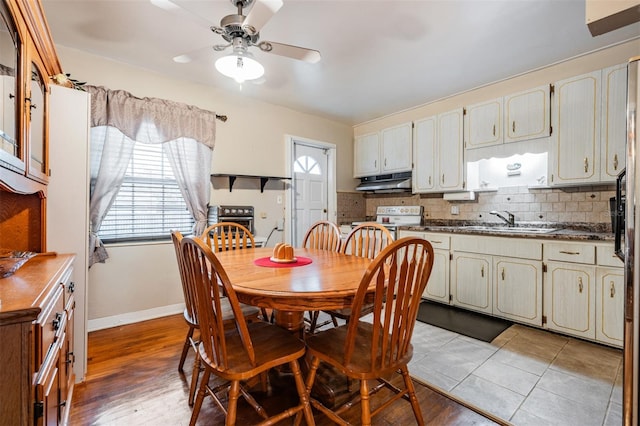 dining space with ceiling fan, light tile patterned flooring, and sink