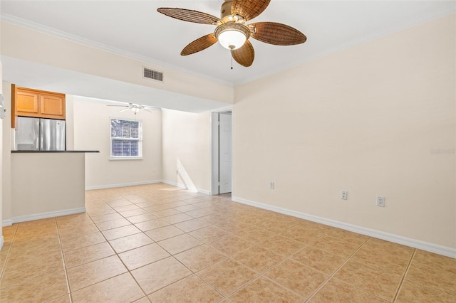 spare room with ceiling fan, light tile patterned floors, and crown molding