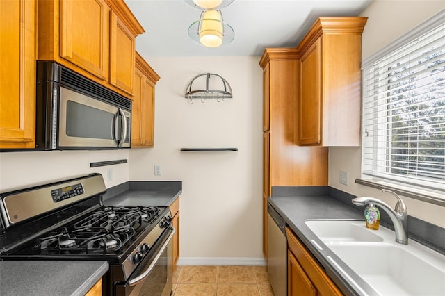 kitchen with light tile patterned floors, appliances with stainless steel finishes, and sink