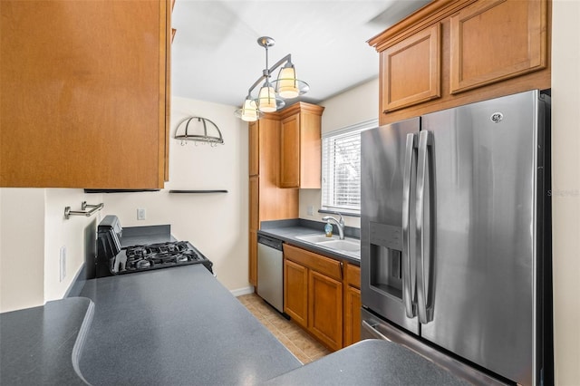 kitchen featuring light tile patterned floors, sink, pendant lighting, and appliances with stainless steel finishes