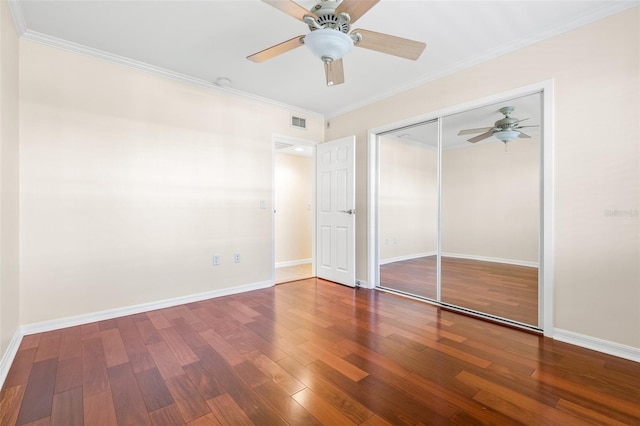 unfurnished bedroom with ceiling fan, a closet, crown molding, and hardwood / wood-style floors