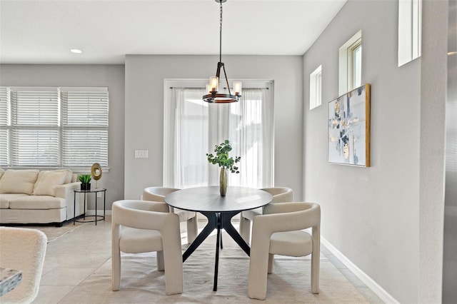 dining space featuring light tile patterned flooring and a chandelier