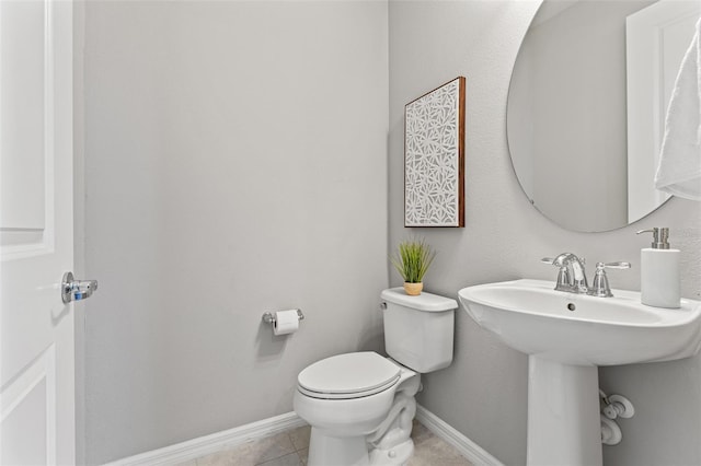 bathroom featuring sink, tile patterned floors, and toilet