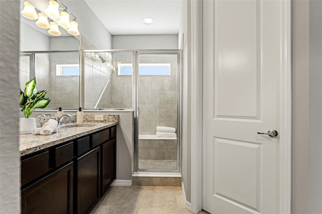 bathroom featuring tile patterned floors, a shower with shower door, and vanity