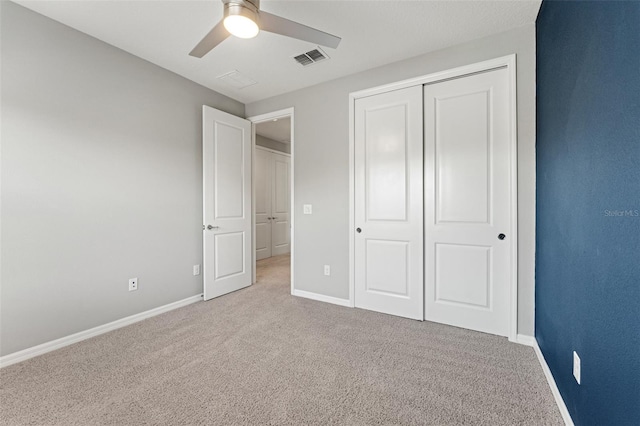 unfurnished bedroom with ceiling fan, a closet, and light carpet