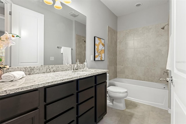 full bathroom featuring vanity, tile patterned flooring, tiled shower / bath combo, and toilet