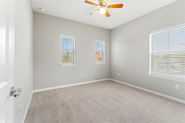 carpeted spare room featuring ceiling fan