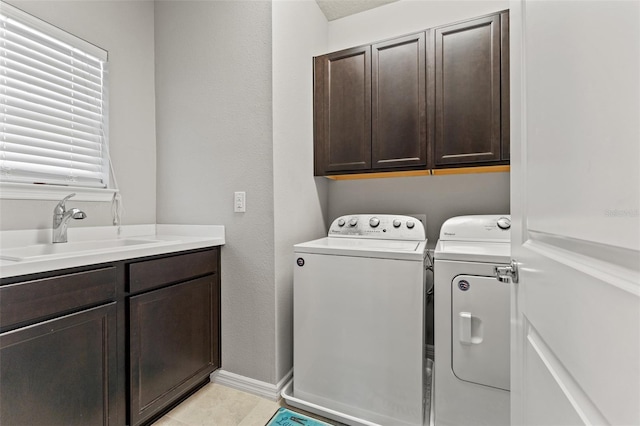 clothes washing area with sink, cabinets, light tile patterned flooring, and independent washer and dryer