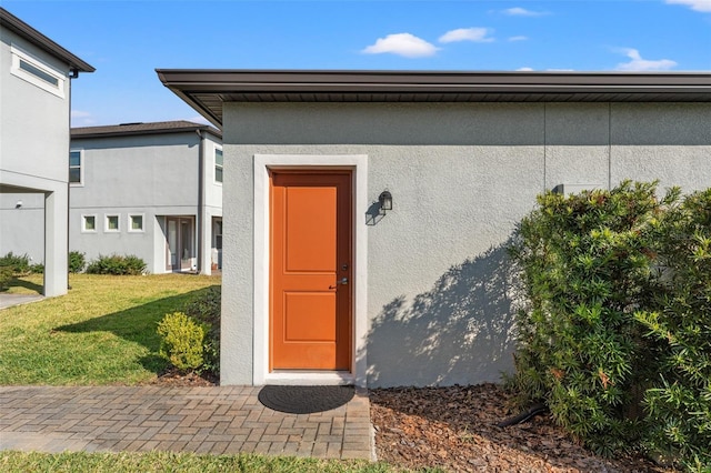 doorway to property with a lawn