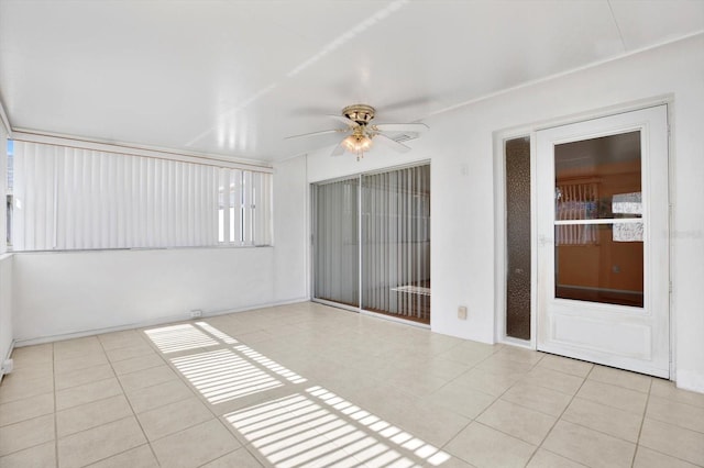 unfurnished sunroom featuring ceiling fan