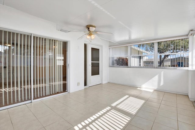 unfurnished sunroom with ceiling fan