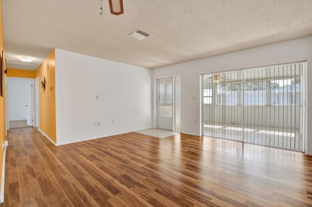 empty room featuring a textured ceiling, ceiling fan, and hardwood / wood-style flooring