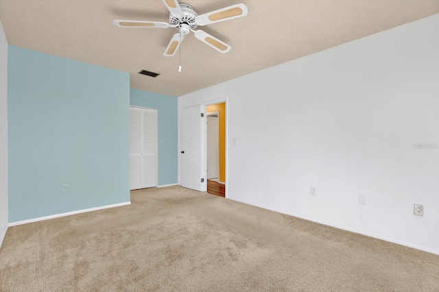 carpeted spare room featuring ceiling fan