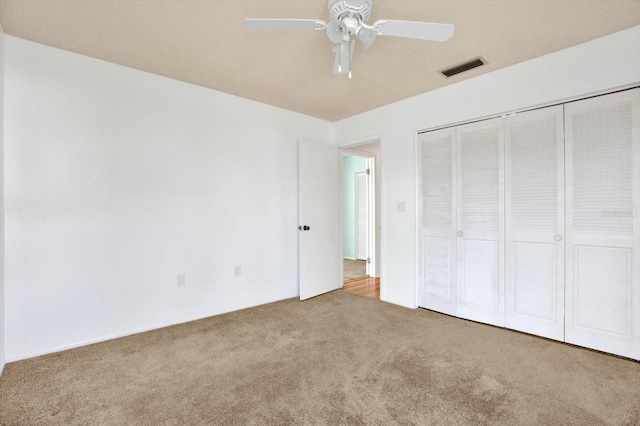 unfurnished bedroom featuring ceiling fan, a closet, and carpet floors