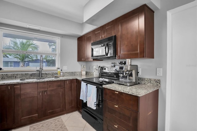 kitchen featuring black appliances, sink, light tile patterned flooring, light stone counters, and dark brown cabinets