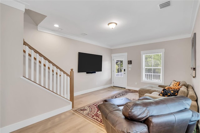 living room featuring ornamental molding and light hardwood / wood-style flooring