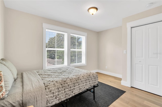 bedroom with light wood-type flooring and a closet