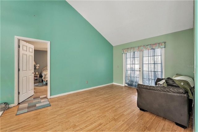 sitting room with vaulted ceiling, french doors, and light hardwood / wood-style floors