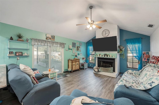 living room with vaulted ceiling, ceiling fan, a fireplace, and hardwood / wood-style flooring