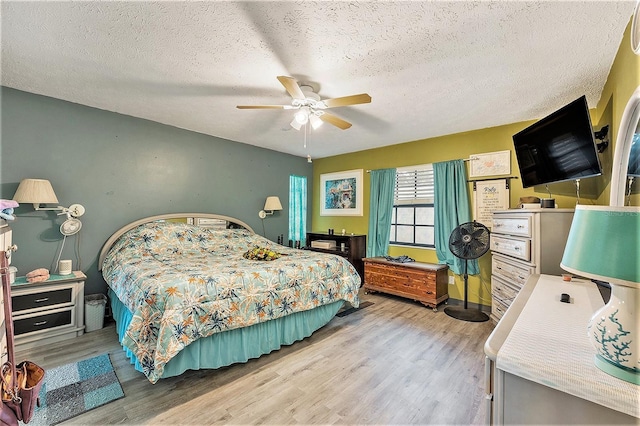 bedroom featuring a textured ceiling, ceiling fan, and light hardwood / wood-style floors