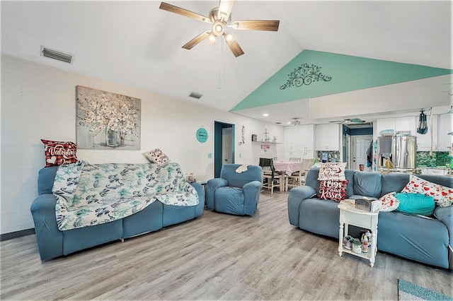 living room featuring ceiling fan, light hardwood / wood-style flooring, and high vaulted ceiling