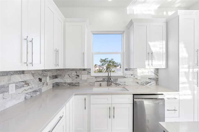 kitchen with dishwasher, decorative backsplash, sink, white cabinetry, and light stone counters