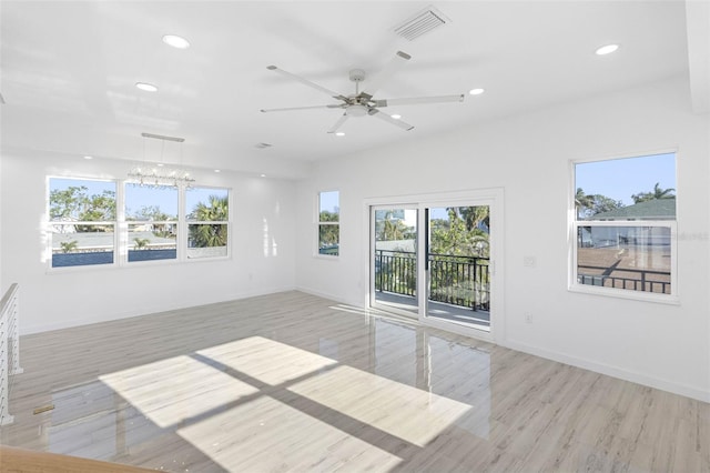 spare room with light hardwood / wood-style floors and ceiling fan with notable chandelier