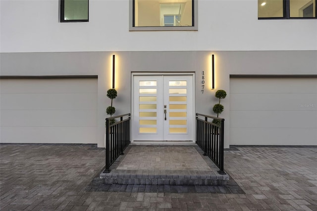 view of exterior entry featuring french doors and a garage