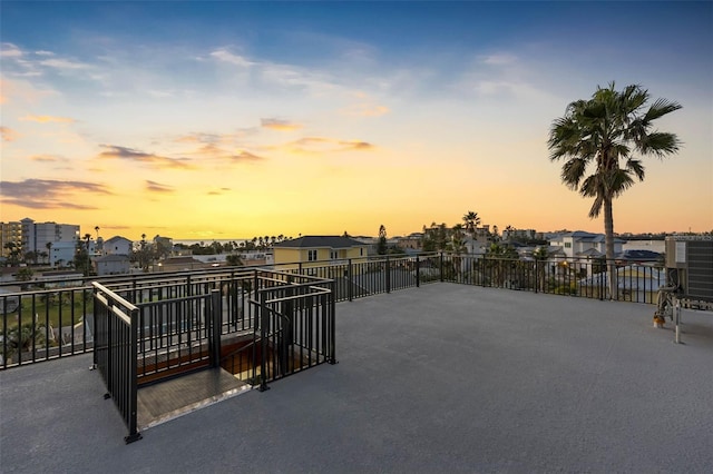 patio terrace at dusk featuring a balcony