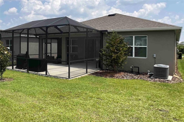 rear view of house featuring a yard, a lanai, central AC unit, and a patio