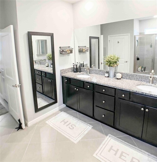 bathroom with tile patterned flooring, walk in shower, and vanity