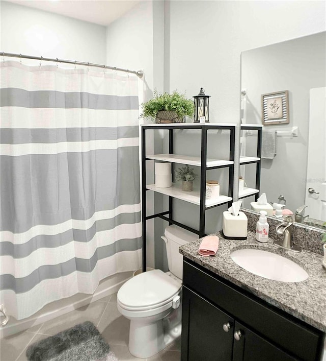 bathroom featuring toilet, tile patterned flooring, vanity, and walk in shower