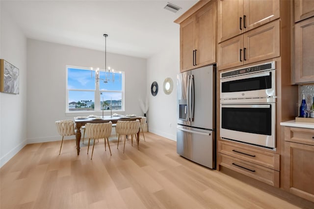 kitchen with light hardwood / wood-style flooring, hanging light fixtures, stainless steel appliances, a chandelier, and light brown cabinets